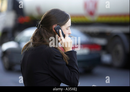 langen dunklen Haaren Irin mit dem Haar Clip tragen schwarze Jackett auf einem Nokia-Handy vor Verkehr in dublin Stockfoto