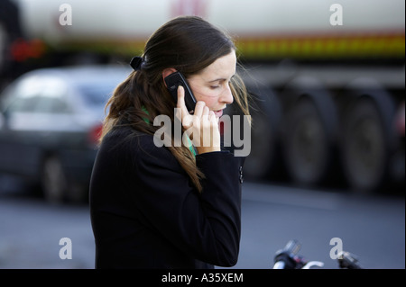 langen dunklen Haaren Irin mit dem Haar Clip tragen schwarze Jackett auf einem Nokia-Handy vor Verkehr in dublin Stockfoto
