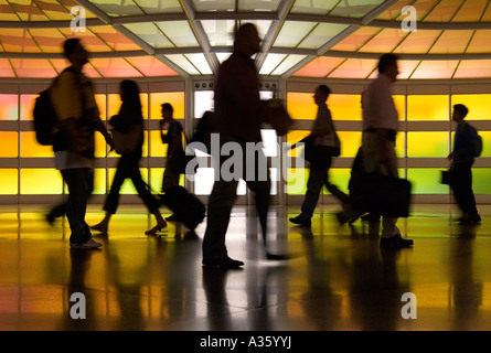 Silhouetten von Reisenden eilen über einen Flughafen. Stockfoto