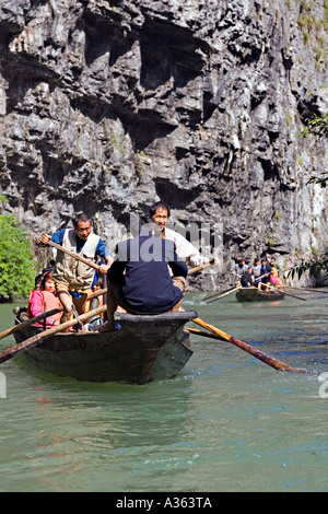 CHINA YANGTZE RIVER Tujia Männer gleich ihr Einkommen durch Rudern und ziehen ihre langen, schmalen Peapod Boote Stockfoto