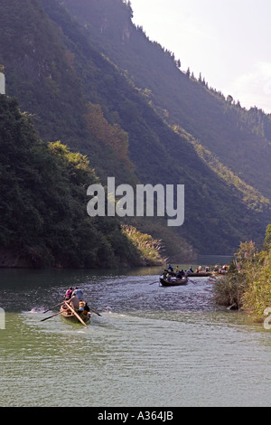 CHINA YANGTZE RIVER Tujia Männer ergänzen ihr Einkommen durch Rudern und ziehen ihre langen, schmalen Peapod Boote Stockfoto