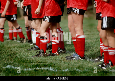 Eine Reihe von weiblichen Fußballer sind aufgereiht und gesehen von den Beinen nach unten auf einem grünen Fußballfeld Stockfoto