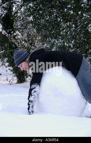 Teenager müde vom Schneemann bauen Stockfoto