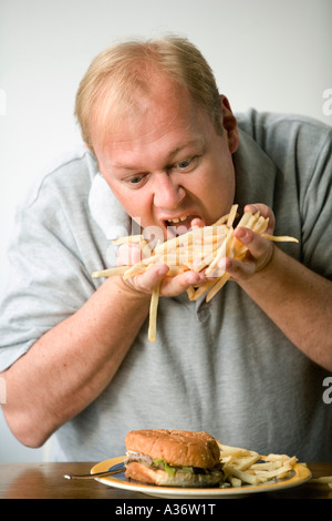 Menschen fressen auf Pommes frites oder dünne Späne mit einem Burger noch zu kommen Stockfoto