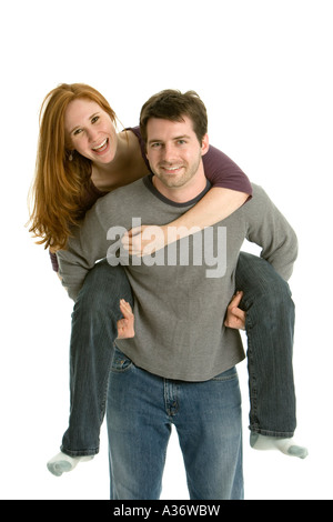 Fröhlicher Junge trägt Freundin lachend auf dem Rücken. Stockfoto