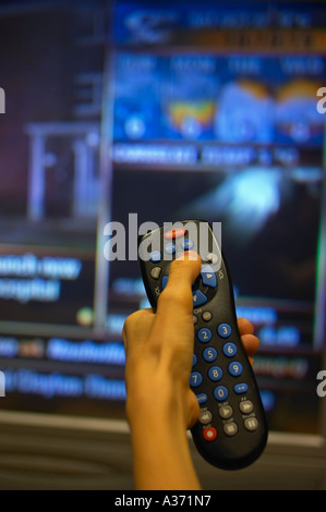 Frauenhand auf Fernbedienung, Surfen Kanäle. Fernsehen - Nachrichten, Wetter. Fernsehen. Stockfoto