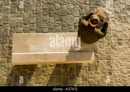 Ein älterer Herr auf einer Bank entlang der Seine Zeitung lesen Stockfoto