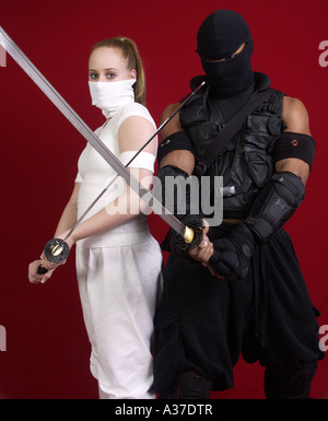 Männlichen und weiblichen Ninjas, Samuraischwerter schwingen. Stockfoto