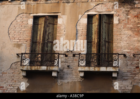 Windows mit Balkon an der Seite eines Hauses in Venedig Italien zeigen Erosion von Wind und Salzwasser Stockfoto