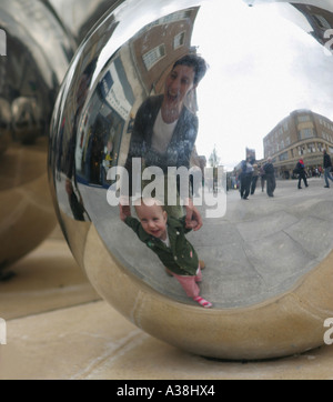 Mutter und Kind genießen ihre Reflexionen in Exeter Rätsel Skulptur Stockfoto