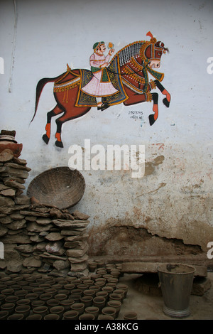 Wandmalerei von einem Bräutigam auf einem Pferd und Lehm Tassen Trocknung in einer Seitenstraße von Udaipur, südlichen Rajasthan, Indien Stockfoto