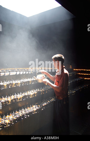 Buddhistischer Mönch Yak-Butter Kerzen auf die Pilger-Schaltung im Jokhang-Tempel in Barkhor Square, Lhasa, Tibet, China Stockfoto