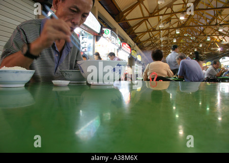 Lokale Mann isst eine Schüssel mit Nudeln an Maxwell Hawker Centre, Singapore Stockfoto