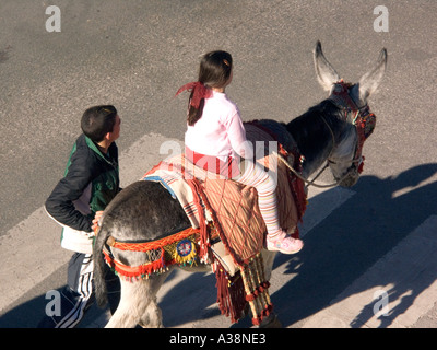 Esel-Taxi nimmt kleine Mädchen auf eine Fahrt durch die Stadt, Mijas Pueblo, Andalusien, Spanien, Europa, Stockfoto