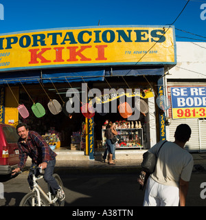 Shop Verkauf von verschiedenen waren auf einer Straße in Mazatlan, Sinaloa Mexiko während ein Radfahrer auf der linken Seite führt. Stockfoto