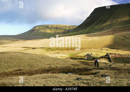 Zwei Wanderer bewundern den See Llyn y Fan Fach und Carmarthen Fan Böschung aus öffnen Moor am Schwarzen Berg Mid Wales UK Stockfoto