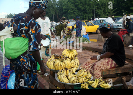 Auf einem belebten Bamako verkauft Straße a Frauen Bananen auf Passanten Mali, Afrika Stockfoto