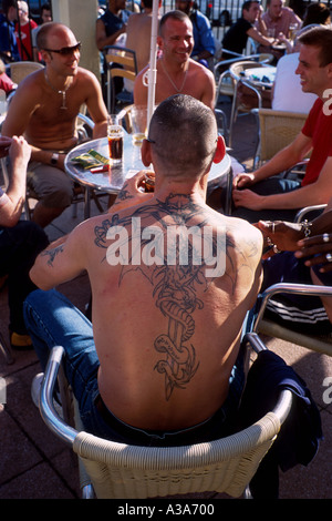 Mann mit Tattoo auf dem Rücken an der Kneipe Amsterdam in Brighton Stockfoto