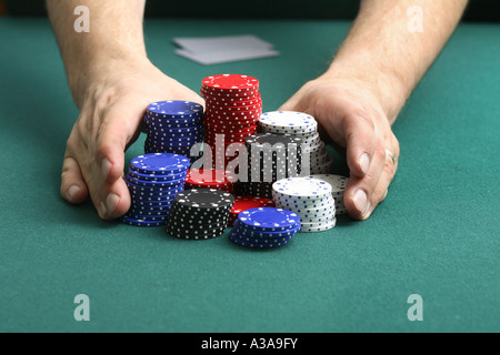 Going "All In"--Poker Spieler Chips schiebt, um eine Wette zu machen. Stockfoto