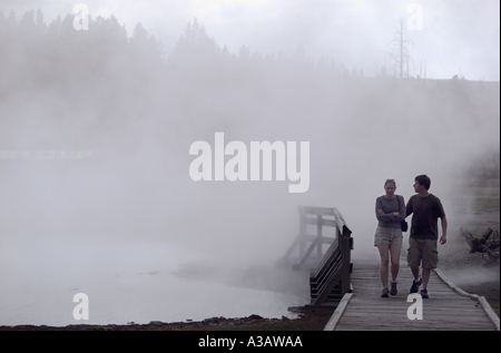 Paar durch thermische Nebel auf einer Promenade an der Kette von Seen, Yellowstone National Park Vereinigte Staaten Amerika Stockfoto