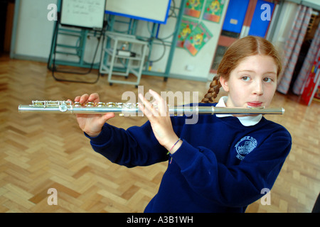 Grundschule Mädchen übt ihre Querflöte bei Schule West Yorkshire Stockfoto