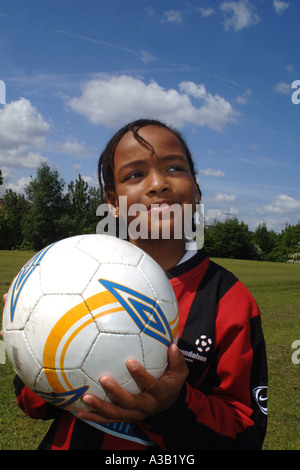 Mädchen hält einen Fußball auf dem Spielfeld Schule West Yorkshire Stockfoto