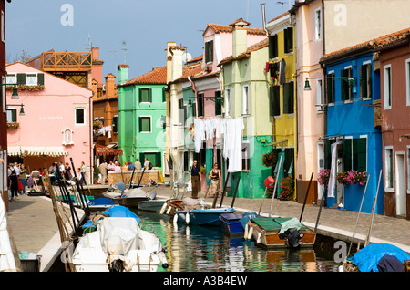 Italien Venetien Venedig Lagune Burano Inseltouristen im Restaurant im Freien neben Colouful Häusern am Kanal mit waschen, trocknen Stockfoto