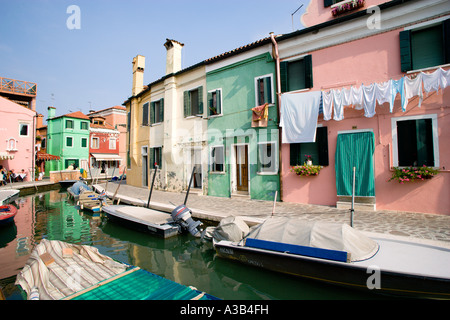 Italien Venetien Venedig Lagune Burano Insel bunten Häuser durch Kanal mit Touristen im Restaurant und Waschen Trocknen auf Haus Stockfoto