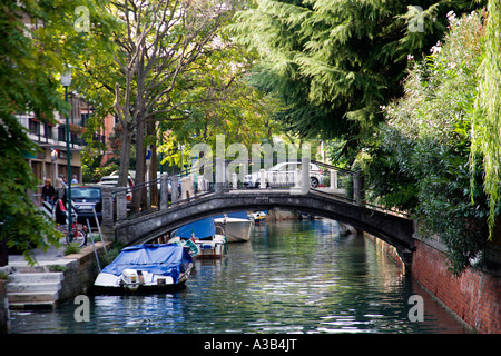 Italien Venetien Venedig Lido A Fußgängerbrücke über einen kleinen Kanal mit Booten vertäut auf der einen Seite. Stockfoto