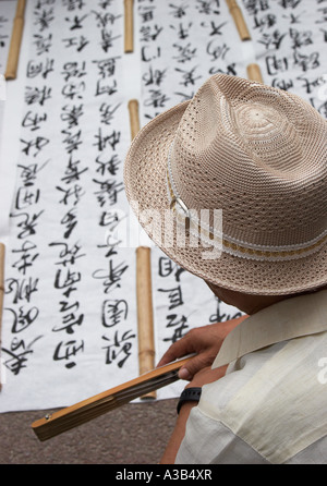 Mann, Blick auf chinesischen Schriftzeichen auf Papier Stockfoto