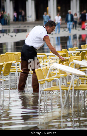 Italien Venetien Venedig St. Mark's Square Aqua Alta Hochwasser Überschwemmung Kellner tragen Wader Stiefel Vorbereitung Restauranttische Stockfoto