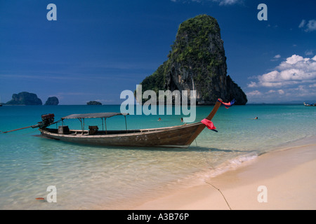 THAILAND Südostasien Krabi Provinz Ao Phra Nang Beach mit Longtail-Boot vertäut im flachen Wasser mit Karst Kalksteininsel Stockfoto