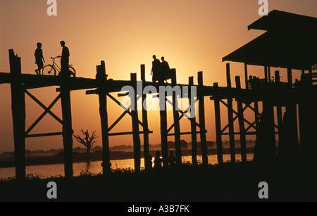 MYANMAR Burma Südost Asien Amarapura U Bein Brücke in der Nähe von Mandalay bei Sonnenuntergang mit silhouettenhafte Figuren der Mönche Kinder- und Radfahrer Stockfoto