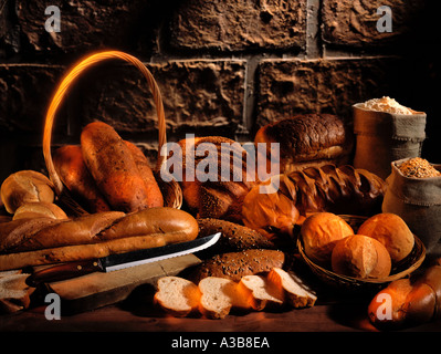BROT-SCHUSS AUF RUSTIKALEN TISCH MIT ZUTATEN Stockfoto