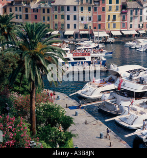 Italien Ligurien Bari Provinz Portofino Blick über Hafen mit bunten Häusern gesäumt von Menschen auf festgemachten Yachten und Motorboote Stockfoto