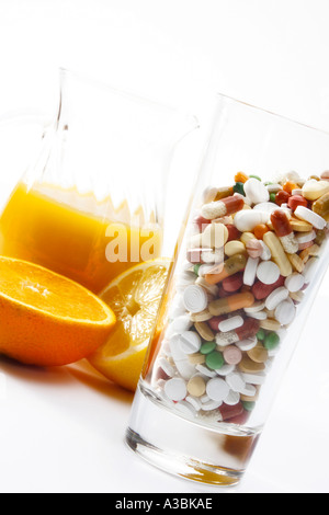 Orangensaft und Pillen in Glas, Nahaufnahme Stockfoto