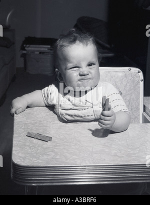 Altes schwarz-weiß Foto eines jungen Kleinkind im Hochstuhl Stockfoto