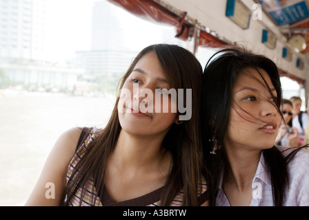 Zwei junge Thai-Frauen haben einen Tagesausflug auf einem Wassertaxi am Fluss Chao Phyra in Bangkok, Thailand Stockfoto