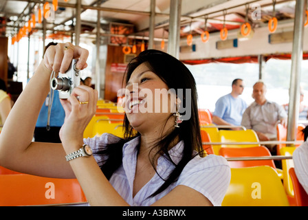 Zwei junge Thai-Frauen haben einen Tagesausflug auf einem Wassertaxi am Fluss Chao Phyra in Bangkok, Thailand Stockfoto