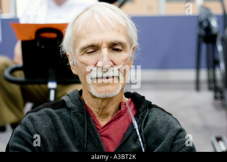 Älterer Mann mit Hilfe einer Sauerstoffmaske wegen seine Lungenkrankheit bei einem lokalen Fitnessstudio ausüben kann. Stockfoto