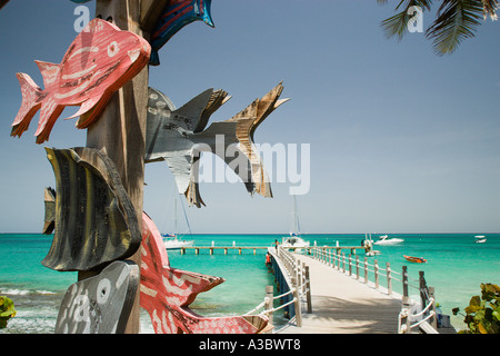 WEST INDIES Karibik St. Vincent der Grenadinen Canouan Island Charles Bay Tamarind Beach aus Holz gemalte Zeichen auf der Zielseite pier Stockfoto