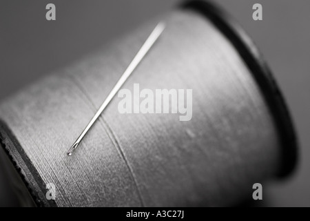 Nahaufnahme von Nadel und Faden mit selektiven Fokus auf das Nadelöhr Stockfoto