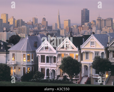 Viktorianische Häuser auf Steiner Strasse mit TransAmerica Tower und San Francisco Skyline bei Sonnenuntergang Stockfoto