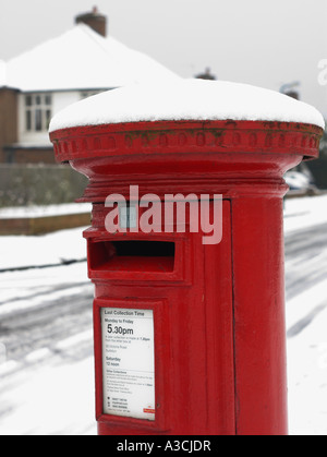 eine schneebedeckte roten Briefkasten in einem Vorort Straße in Thames Ditton Surrey Stockfoto