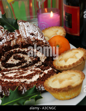 traditionelle Schokolade Bûche und Mince Pies mit Kerze Stockfoto