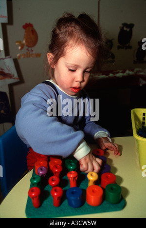 Junge Mädchen nutzt eine Puzzle im Kindergarten, die dabei hilft, Hand-Auge-Koordination Stockfoto