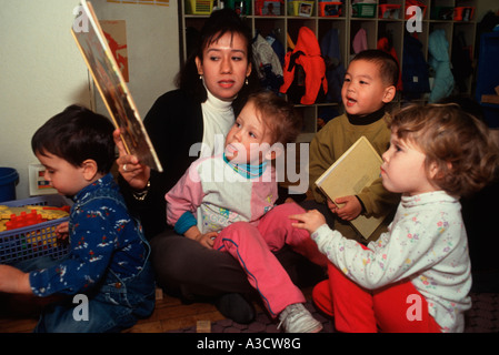 Vorschullehrerin liest eine Geschichte um einer Gruppe von Kindern im freien Raum Kindergarten in Park Slope, Brooklyn NY Stockfoto