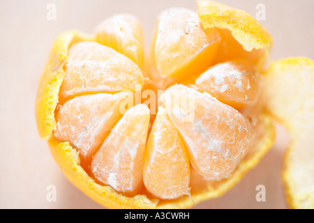 Mandarine geschält teilweise um acht Sektoren zu offenbaren Stockfoto