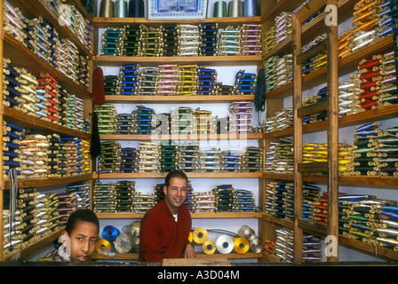 Ein Ladenbesitzer hinter der Theke in seinem bunten Laden verkaufen Seidenfaden im Souk in Fes Marokko Stockfoto