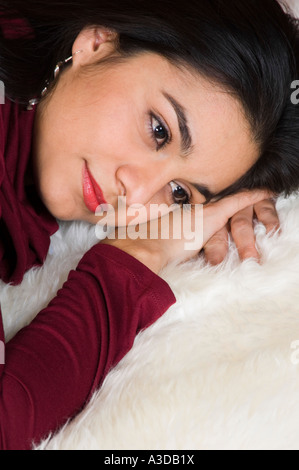 Schöne lateinische Frau Verlegung auf weißem Fell Stockfoto